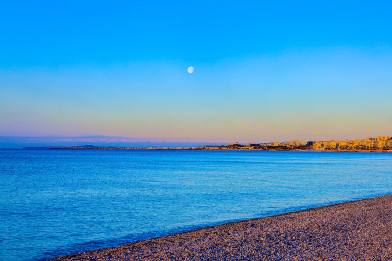 Scenic view of Nice, France in the South of France beach at sunrise with calm waters and colorful skies